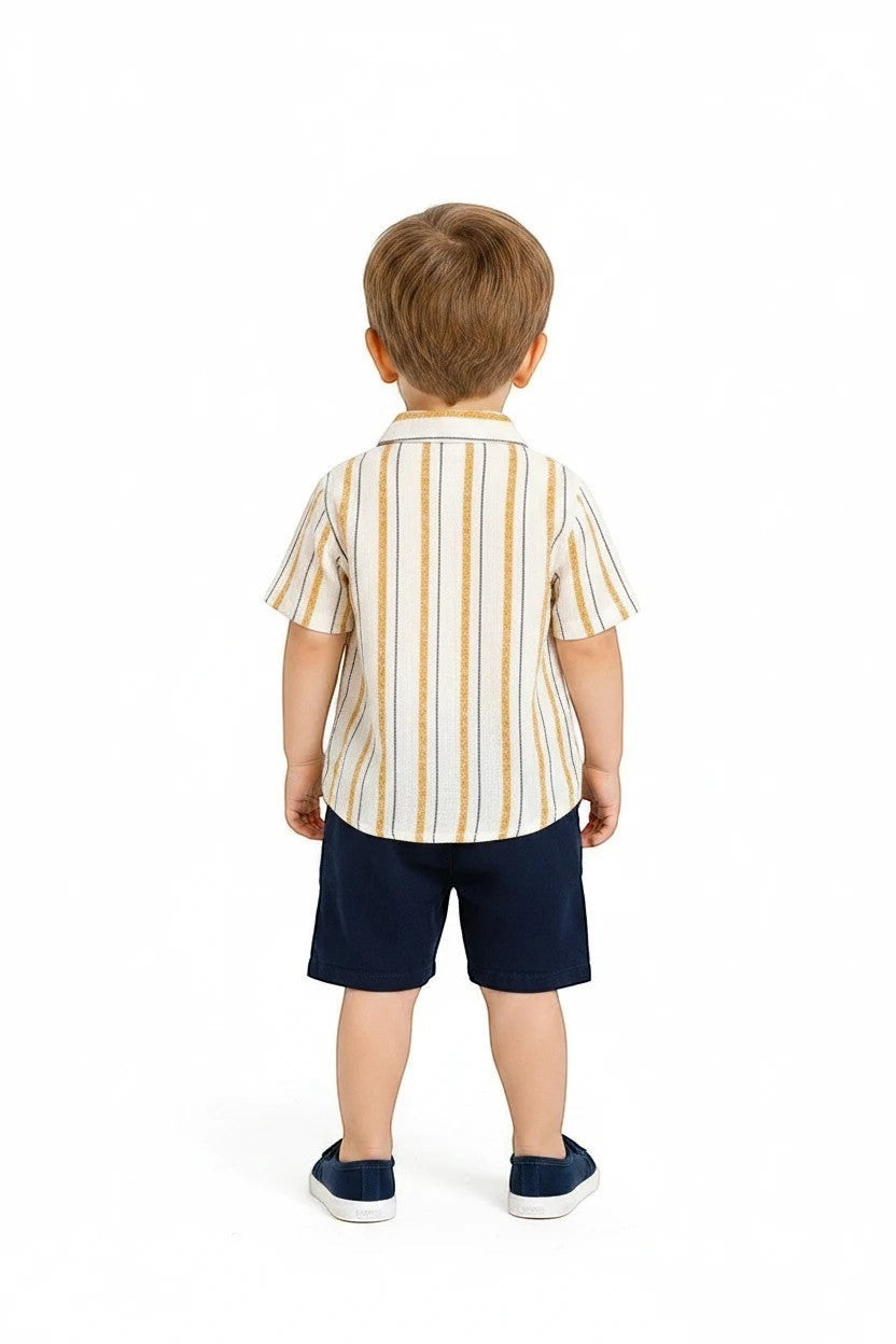 Toddler boy wearing The Nile Luxuries striped short-sleeve shirt and navy blue shorts, back view.