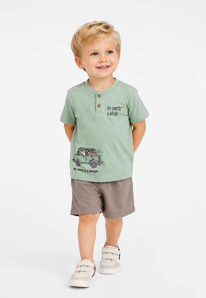 Toddler boy wearing a sage green The Nile Luxuries henley t-shirt with beagle graphic and brown shorts