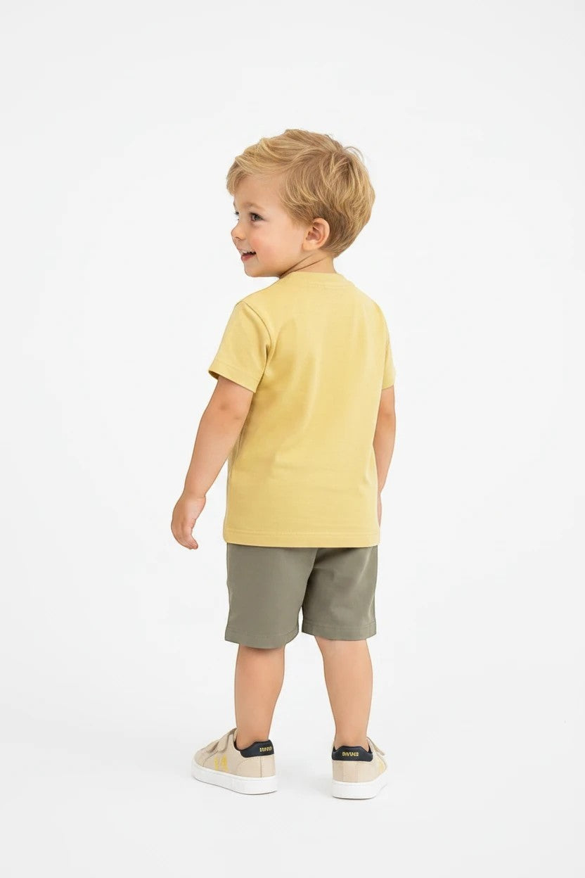 Toddler boy wearing a yellow short-sleeve henley t-shirt and olive shorts from The Nile Luxuries