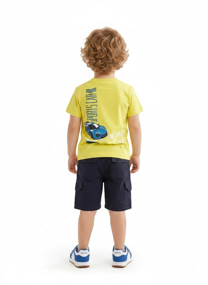 The Nile Luxuries toddler boy wearing a yellow sports car graphic t-shirt and navy blue cargo shorts from behind.