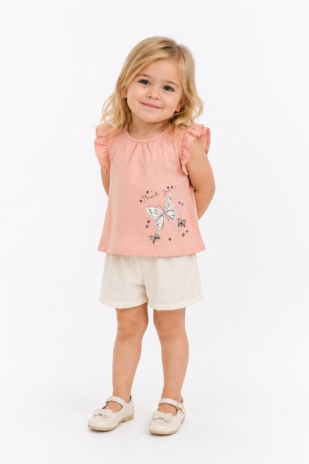 Toddler girl wearing The Nile Luxuries pink flutter sleeve top with butterfly graphic and cream shorts set.
