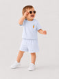 Toddler wearing The Nile Luxuries light blue short sleeve shirt and shorts set with an embroidered carrot detail.