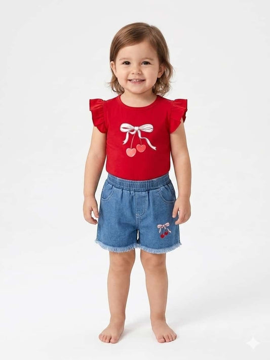 Toddler girl wearing The Nile Luxuries red flutter-sleeve cherry graphic t-shirt and frayed denim shorts set.