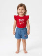 Toddler girl wearing The Nile Luxuries red flutter-sleeve cherry graphic t-shirt and frayed denim shorts set.