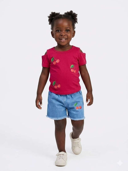Toddler girl wearing The Nile Luxuries cherry print cold-shoulder top and frayed denim shorts set.