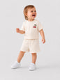Toddler wearing The Nile Luxuries cream short sleeve t-shirt and shorts set with embroidered cherry detail