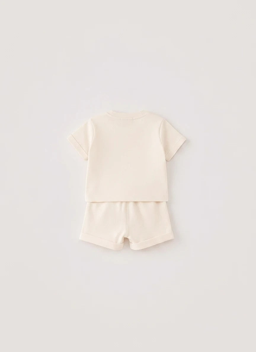 The Nile Luxuries toddler cream short sleeve shirt and shorts set with cuffed hems, back view