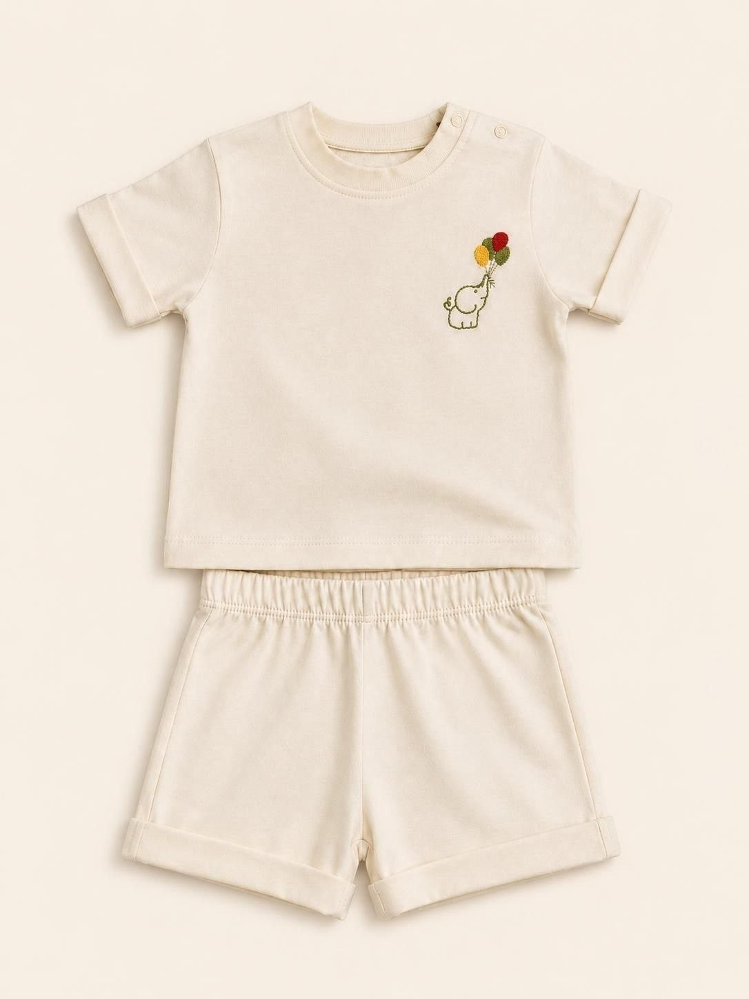 The Nile Luxuries toddler cream short sleeve shirt and shorts set with an embroidered elephant and balloon design.