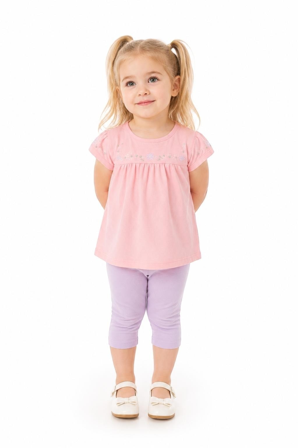 Toddler girl wearing The Nile Luxuries pink embroidered top and purple capri leggings against a white background.