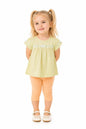 Toddler girl wearing The Nile Luxuries light green embroidered top and peach capri leggings on a white background.
