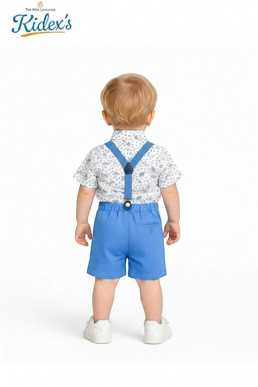 Toddler boy wearing The Nile Luxuries floral shirt, blue shorts, and suspenders from the back against white background