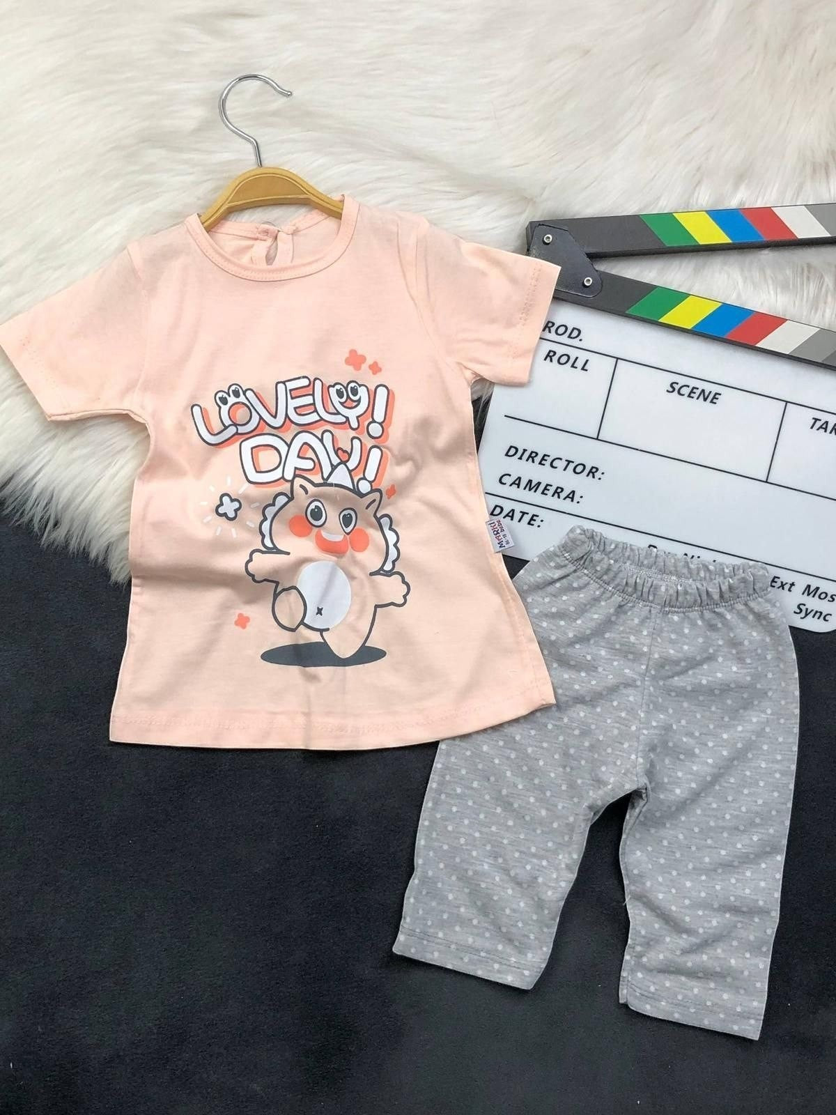 The Nile Luxuries toddler outfit set with a peach graphic t-shirt and grey polka-dot leggings.