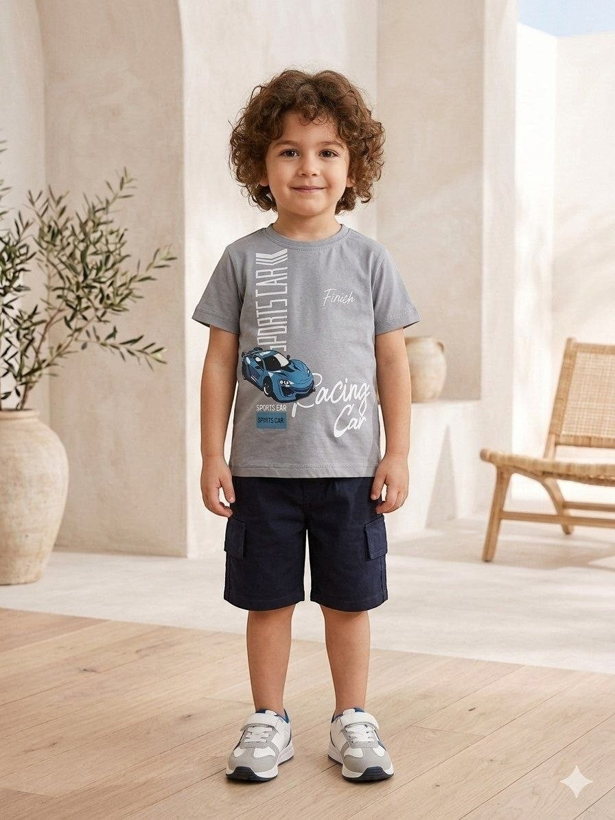 The Nile Luxuries toddler boy wearing a grey graphic sports car t-shirt and navy blue cargo shorts with sneakers.