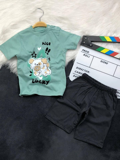 The Nile Luxuries toddler set with a sage green puppy graphic t-shirt featuring shoulder snaps and black shorts.
