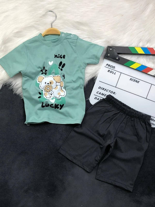 The Nile Luxuries toddler set with a sage green puppy graphic t-shirt featuring shoulder snaps and black shorts.