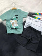 The Nile Luxuries toddler set with a sage green puppy graphic t-shirt featuring shoulder snaps and black shorts.
