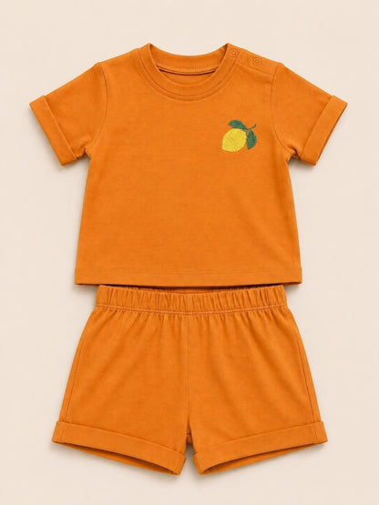 The Nile Luxuries toddler two-piece set in burnt orange with a lemon embroidery, crewneck top, and elastic shorts.