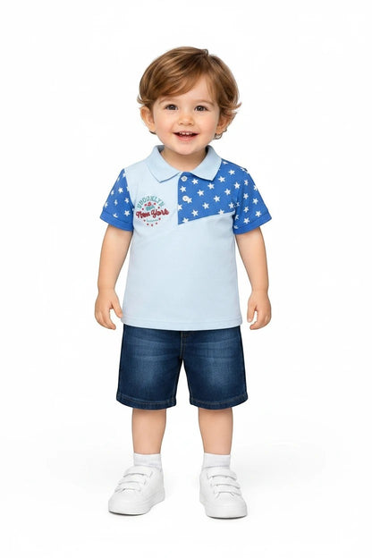 Toddler boy wearing a The Nile Luxuries light blue polo shirt with star print and denim shorts on a white background.