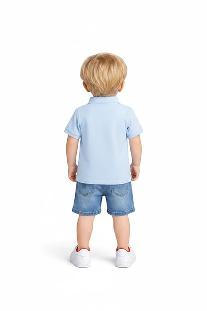 Toddler boy wearing a light blue polo shirt and denim shorts from The Nile Luxuries, back view on white background.