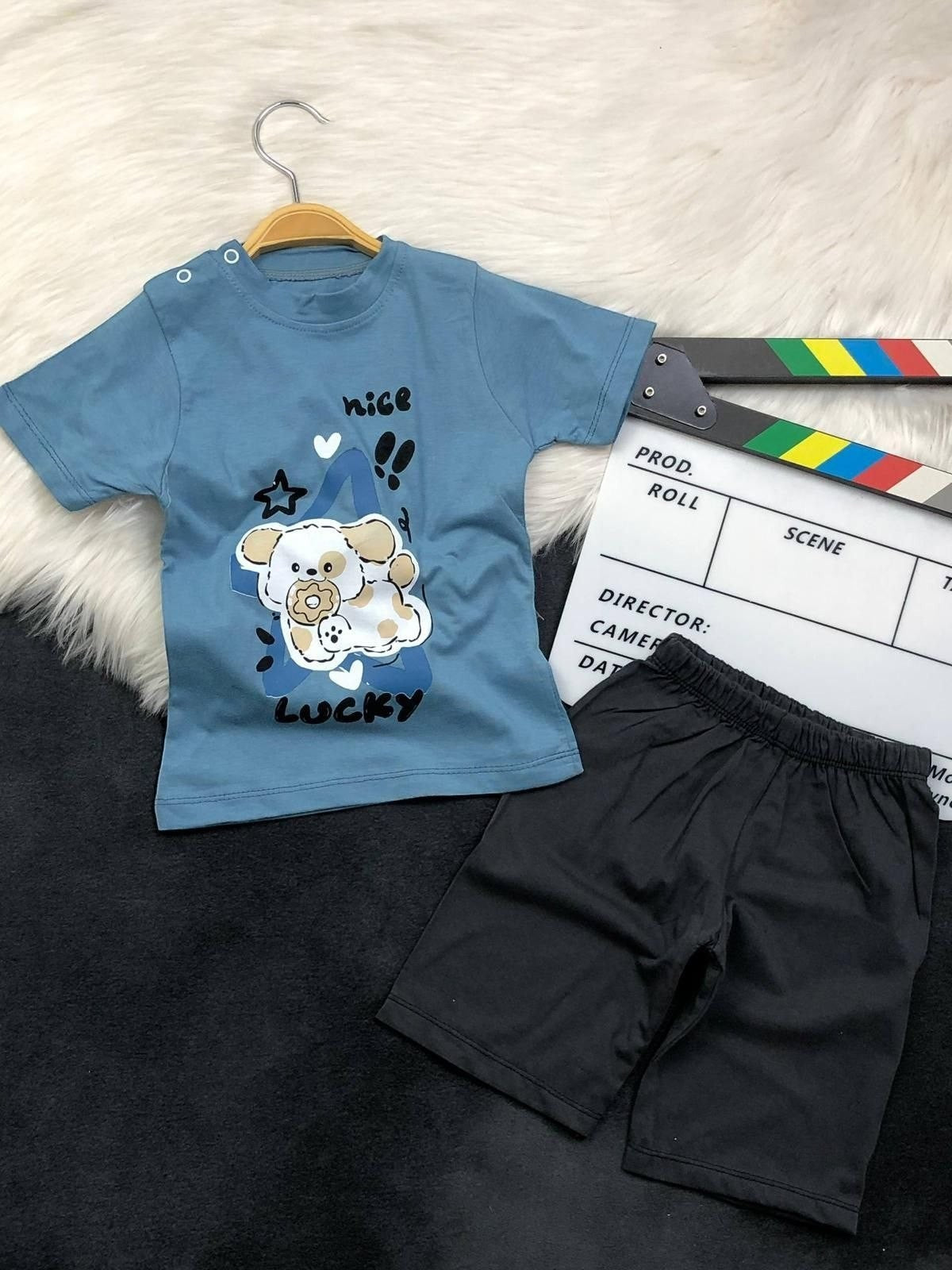 The Nile Luxuries toddler set with a blue puppy graphic t-shirt featuring shoulder snaps and black elastic shorts.