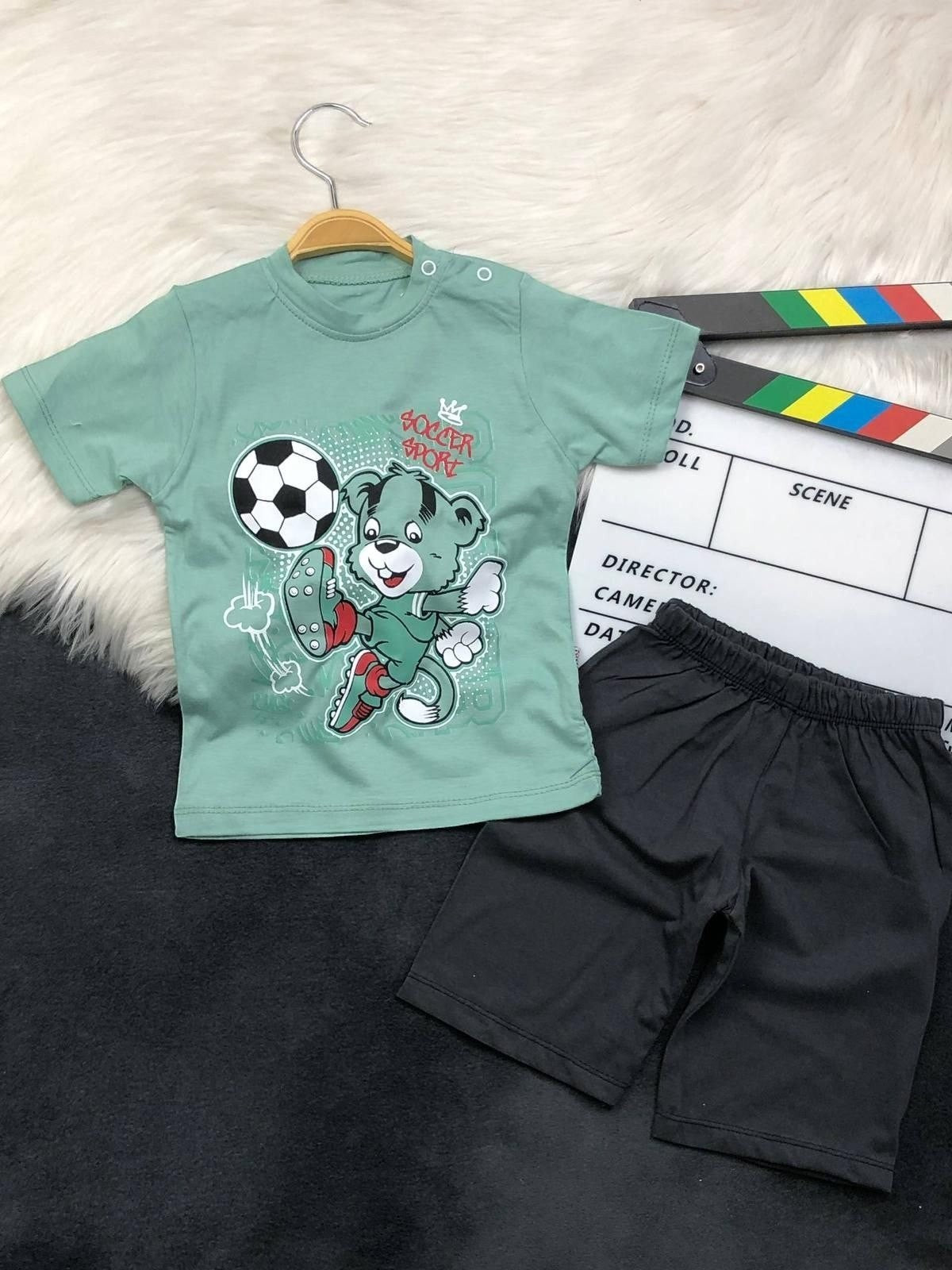 The Nile Luxuries toddler boys set with a sage green soccer bear graphic t-shirt and black pull-on shorts.