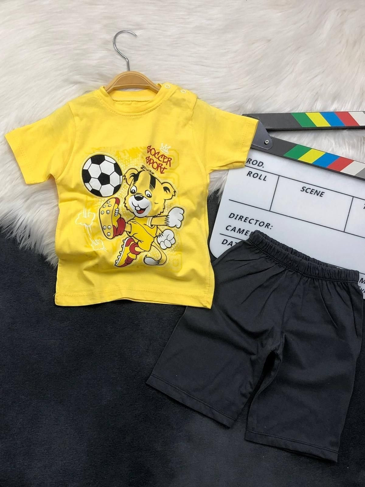 The Nile Luxuries toddler boys yellow soccer bear graphic t-shirt and black shorts set with shoulder snap buttons.