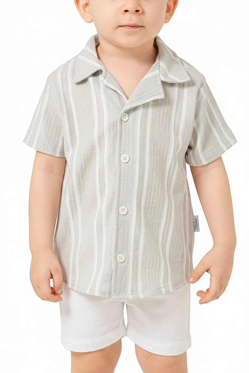 Toddler boy wearing a The Nile Luxuries sage and white striped button-down shirt and white shorts set.