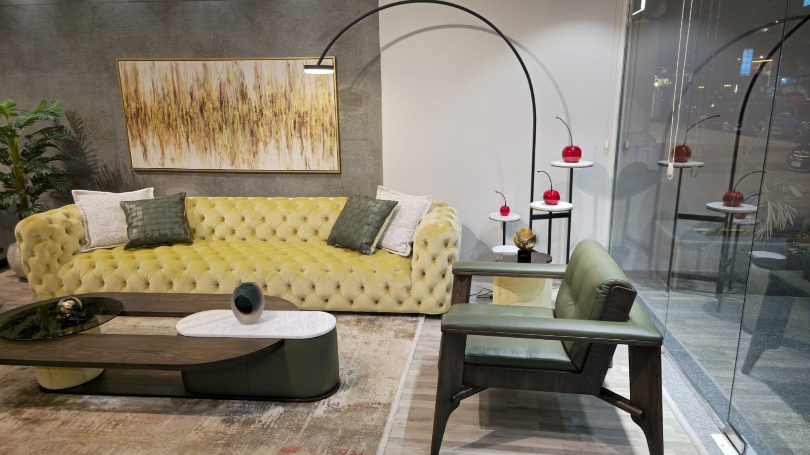 The Nile Luxuries tufted chartreuse velvet sofa with deep button-tufting and decorative pillows. A matching armchair is visible.