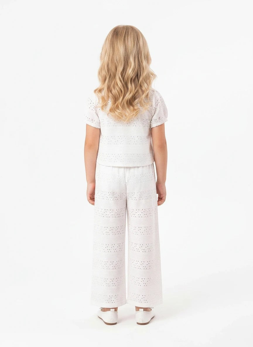 Back view of a girl wearing The Nile Luxuries white eyelet embroidered shirt and wide-leg trouser set.