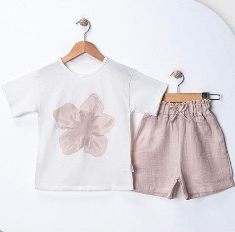 The Nile Luxuries white cotton t-shirt with pink flower graphic and pink linen shorts with drawstring waist.