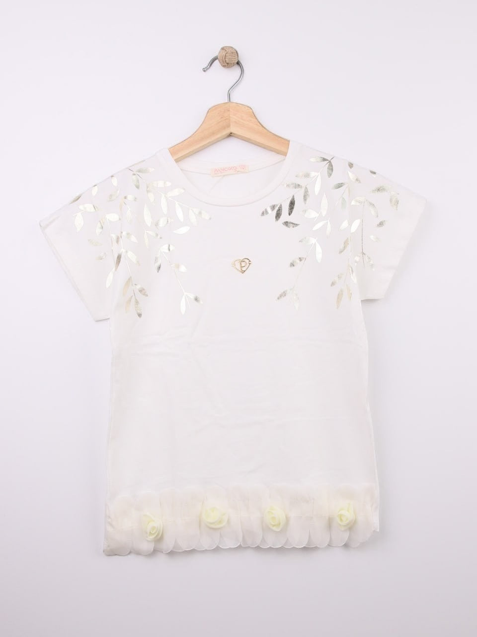The Nile Luxuries white cotton t-shirt with metallic leaf print, gold heart emblem, and ruffled hem with fabric roses.