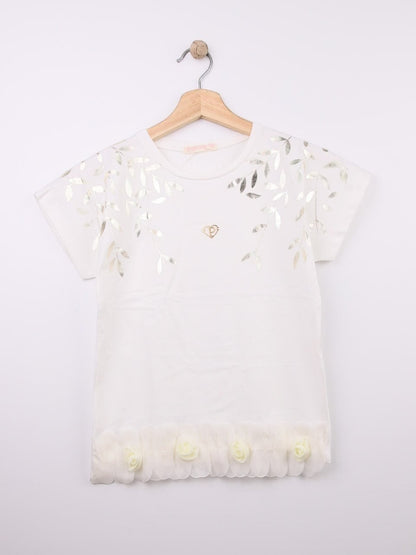 The Nile Luxuries white cotton t-shirt with metallic leaf print, gold heart emblem, and ruffled hem with fabric roses.
