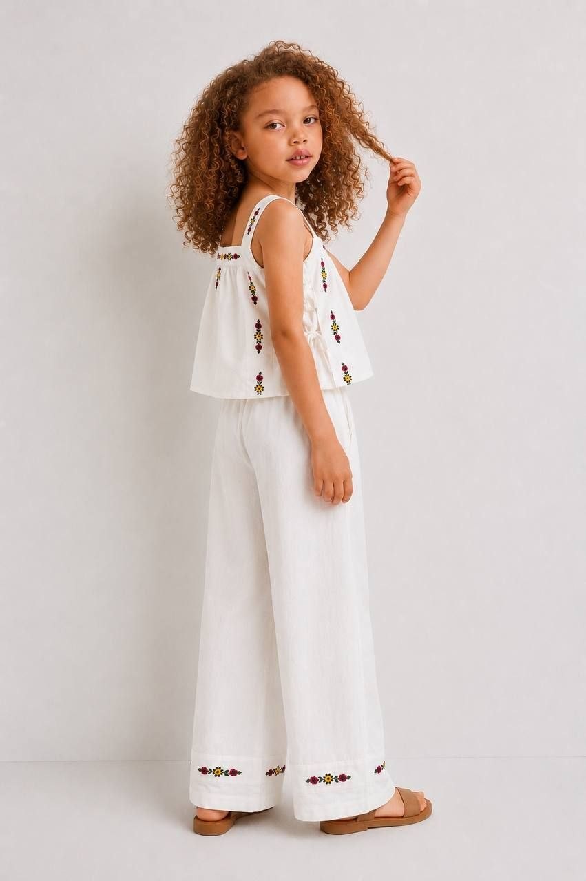The Nile Luxuries white linen blend sleeveless crop top with floral embroidery and wide leg pants set.