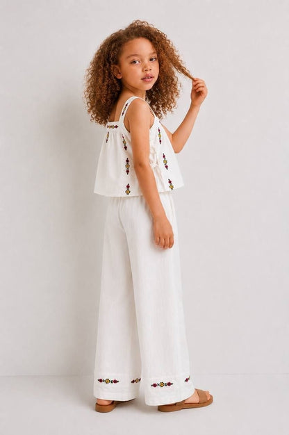 The Nile Luxuries white linen blend sleeveless crop top with floral embroidery and wide leg pants set.