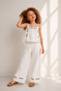 The Nile Luxuries white linen blend set with embroidered crop top and wide leg pants. Floral embroidery in yellow, red, purple.