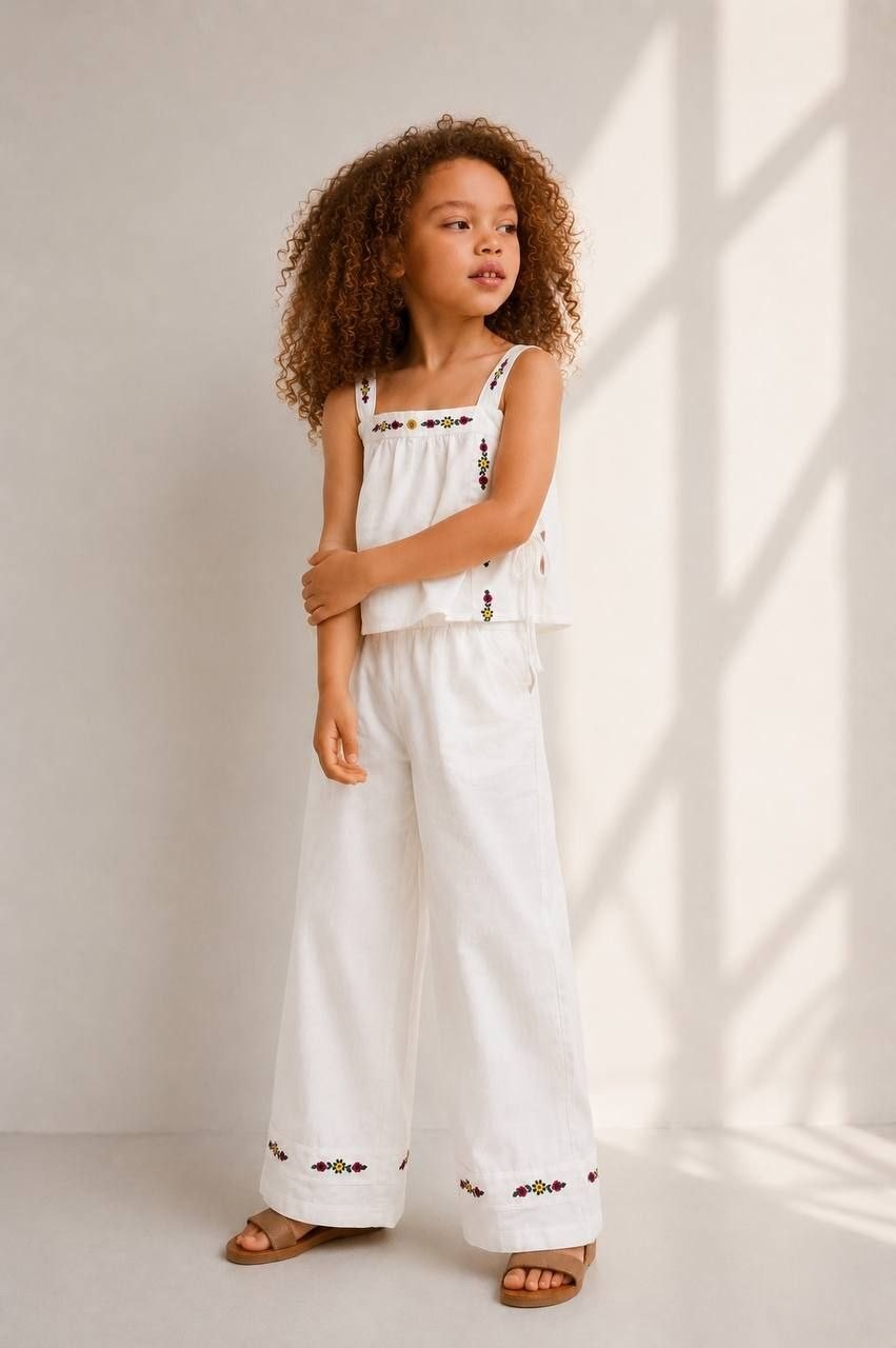 The Nile Luxuries white linen blend wide leg pants set with floral embroidery on neckline and hem. Sleeveless crop top.