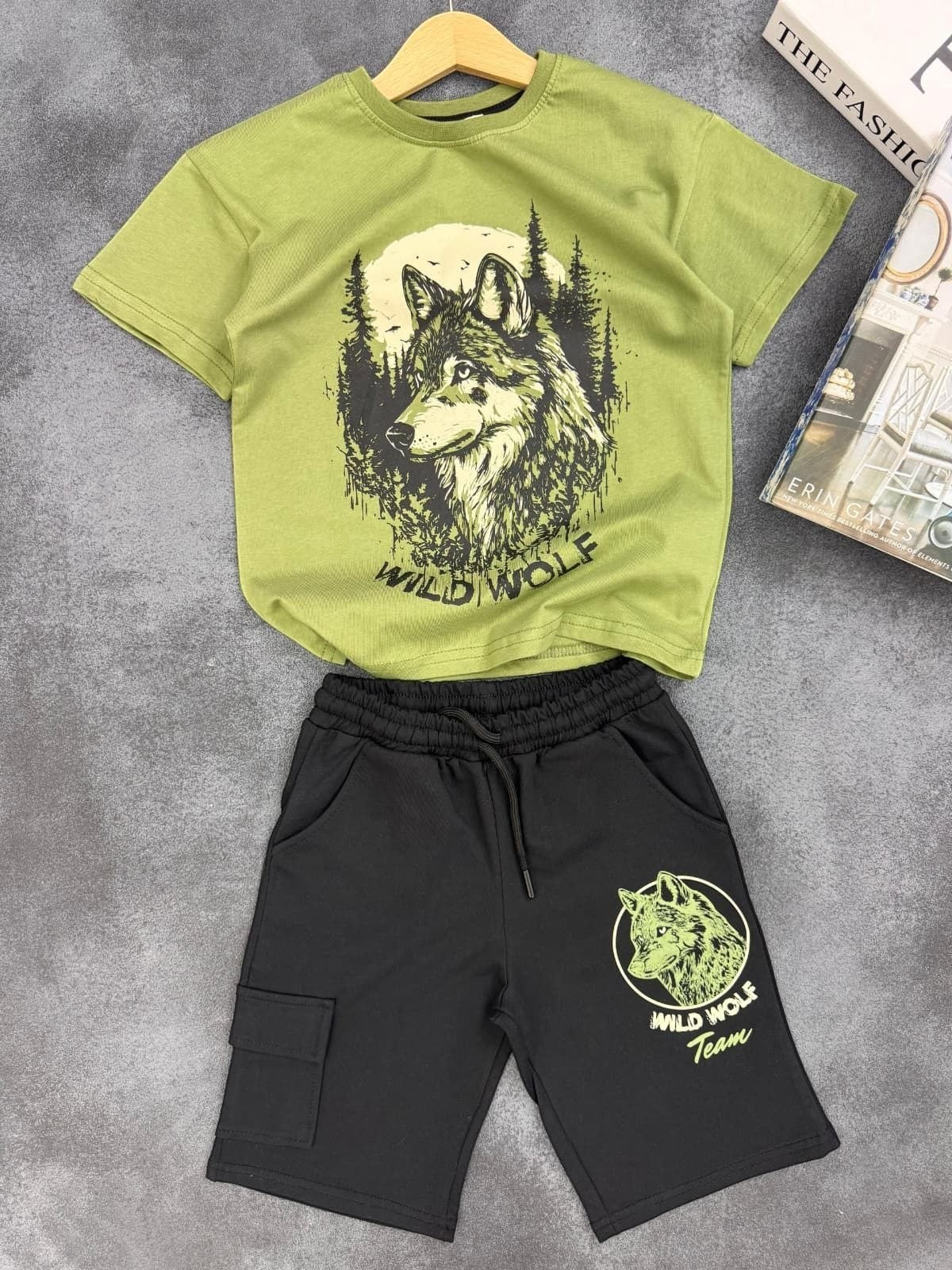 The Nile Luxuries boys two-piece set with olive green wolf graphic t-shirt and black cargo shorts with drawstring.