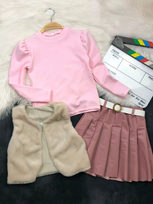 The Nile Luxuries three-piece youth set with a pink ribbed top, beige faux-fur vest, and pleated faux-leather skirt.