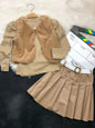 The Nile Luxuries three-piece youth outfit with a beige ribbed top, plush faux-fur vest, and pleated faux-leather skirt.