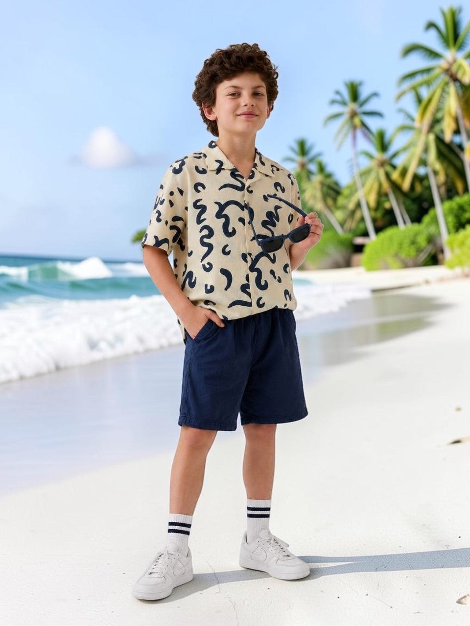 The Nile Luxuries short sleeve collared shirt with abstract navy print on cream fabric. Relaxed fit, perfect for kids.