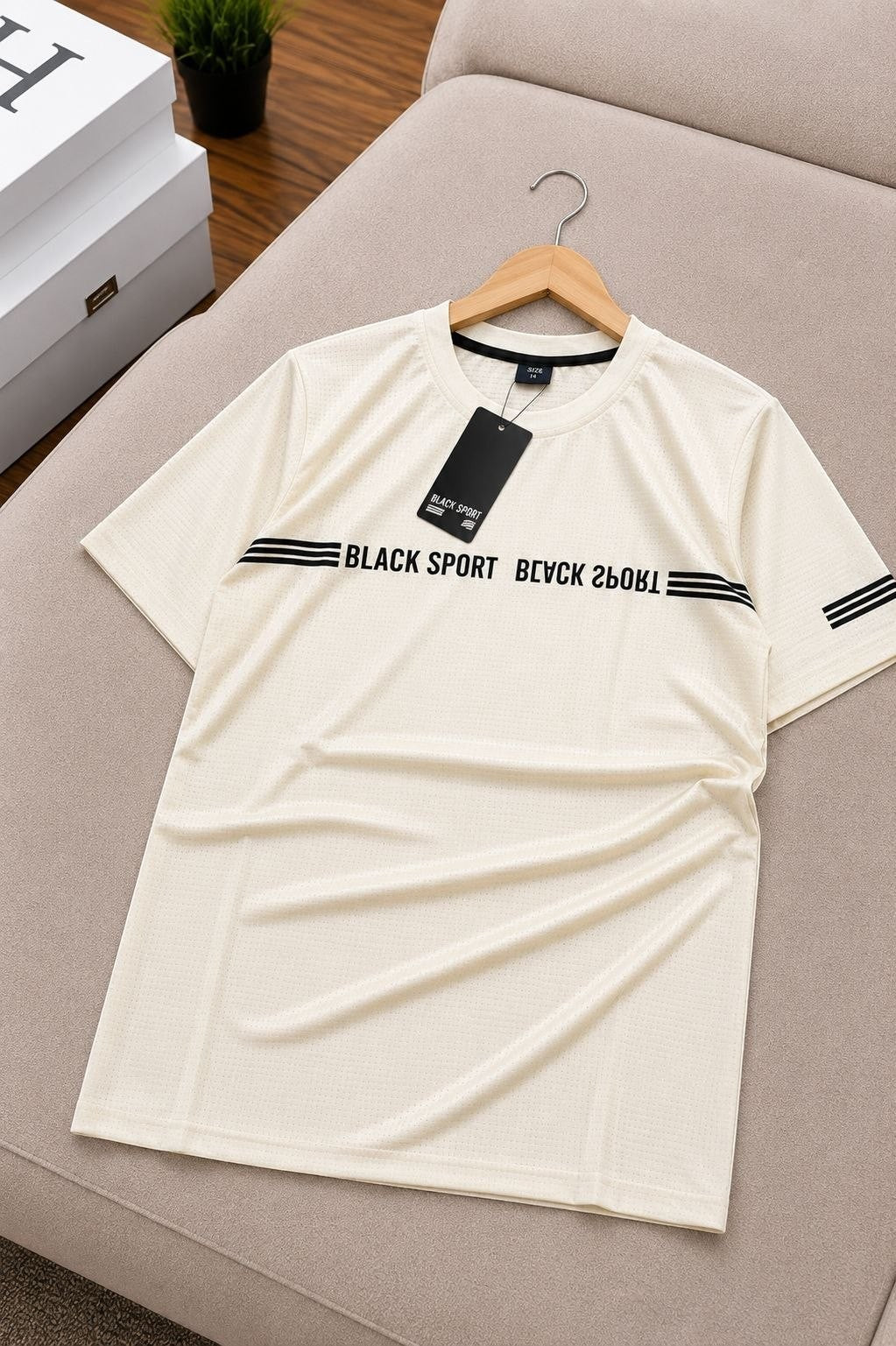 The Nile Luxuries cream athletic t-shirt with black graphic stripes and text detail. Short sleeves, crew neck.