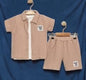 The Nile Luxuries boys' beige gauze shirt and shorts set. Short-sleeved collared shirt with button-down front and elastic-waist shorts, both with embroidered patch.