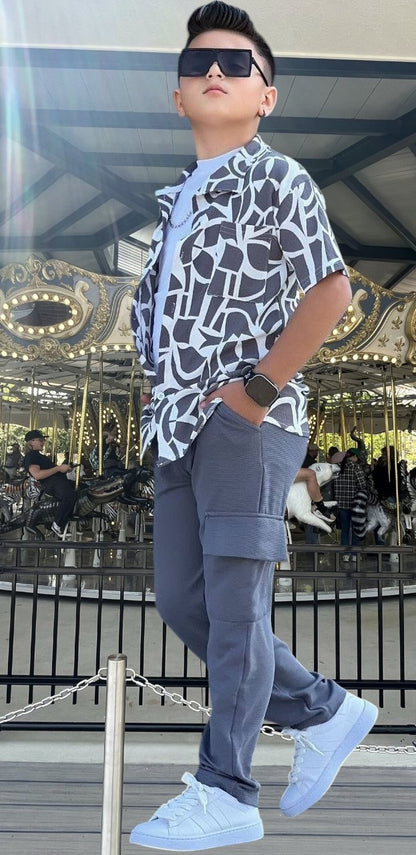 The Nile Luxuries boys' grey cargo pants and abstract print short sleeve shirt set. Features elastic waist pants and button-up shirt.