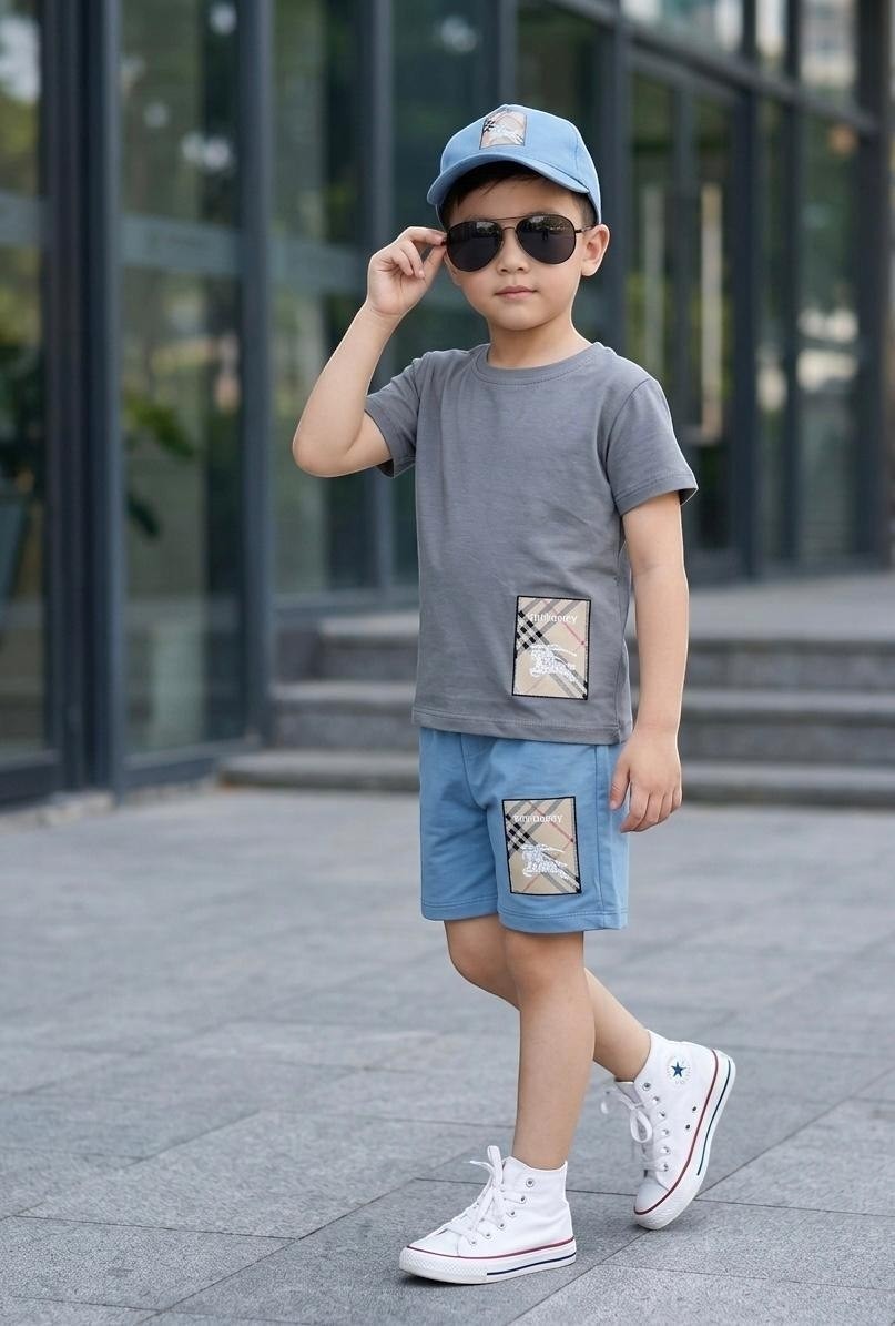 The Nile Luxuries boys' grey t-shirt and blue shorts set with checkered patch detail.