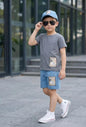 The Nile Luxuries boys' grey t-shirt and blue shorts set with checkered patch detail.