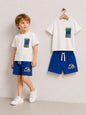The Nile Luxuries boys' white Jurassic World t-shirt and blue shorts set. T-shirt features dinosaur graphic.