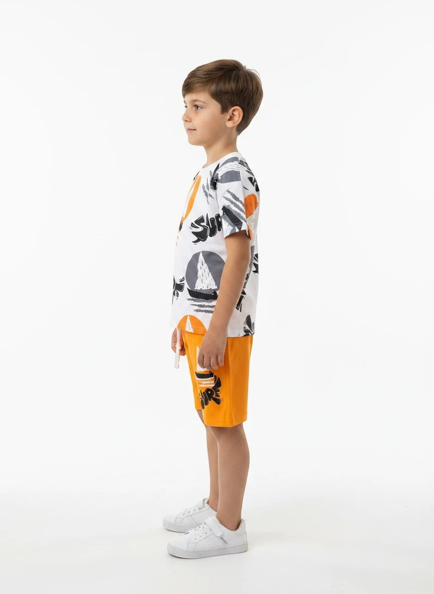 The Nile Luxuries boys' white cotton t-shirt with sailboat graphic and orange shorts. Elastic waistband with drawstring.