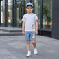 The Nile Luxuries boys' light grey t-shirt and dusty blue shorts set with checkered patch detail.