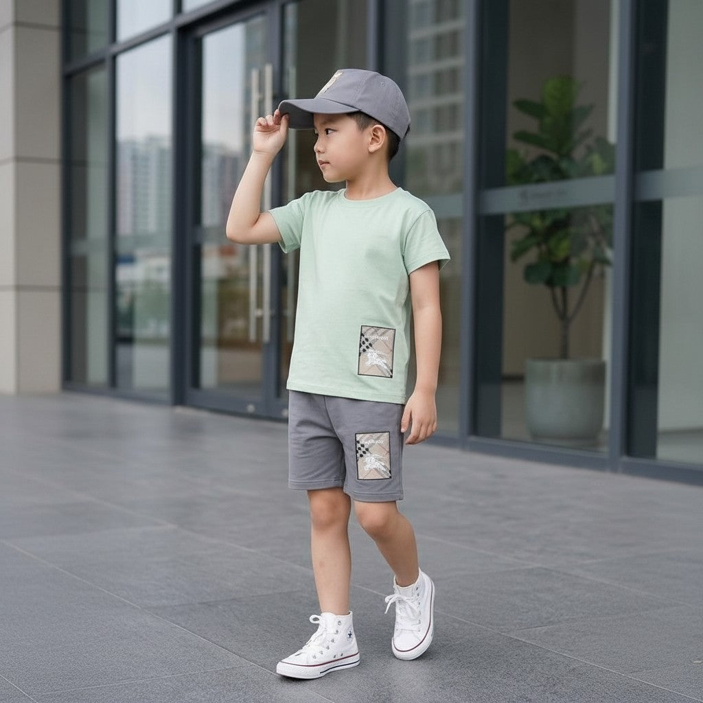 The Nile Luxuries boys' light sage green t-shirt and grey shorts set with checkered patch detail.