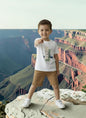 The Nile Luxuries boys white cotton t-shirt with graphic print and tan shorts set. Short sleeves, relaxed fit.